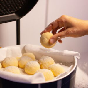 Imagem de pãozinho de tapioca crocante e dourado feito na Airfryer, mostrando sua textura porosa e formato redondo.