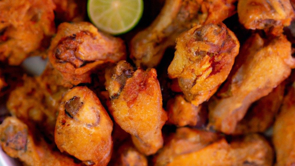 Imagem de peito de frango crocante cozido em uma airfryer em cima de uma tábua de madeira, guarnecido com ervas frescas.