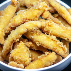 Imagem de peixe frito crocante e dourado na airfryer, com limão e ervas frescas ao lado. A imagem mostra um prato delicioso e crocante, perfeito para um jantar rápido e fácil.