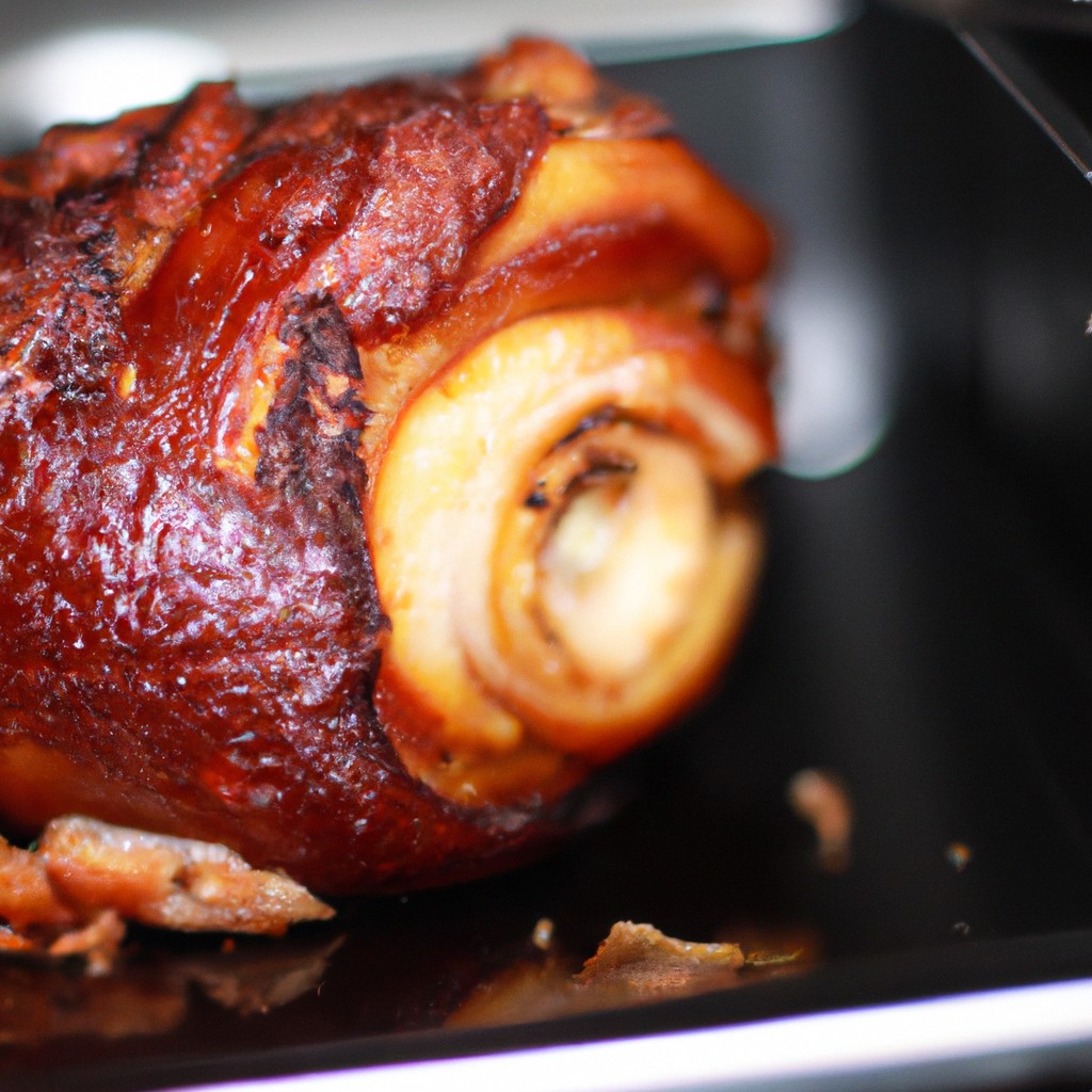 Imagem de um pernil de porco assado na Airfryer, com pele crocante e dourada. O pernil é temperado com ervas e especiarias aromáticas, o que lhe confere um sabor delicioso e suculento.
