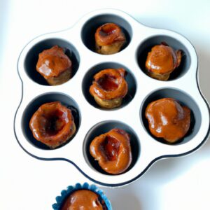 Imagem de um petit gateau feito na airfryer. O petit gateau é coberto com uma calda de chocolate e decorado com uma folha de hortelã.