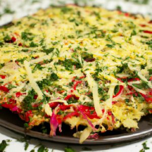 Imagem de uma pizza de couve-flor assada em uma Airfryer, com crosta crocante e dourada, coberta com molho de tomate, mussarela derretida, pimentões verdes e vermelhos, cebolas e cogumelos.