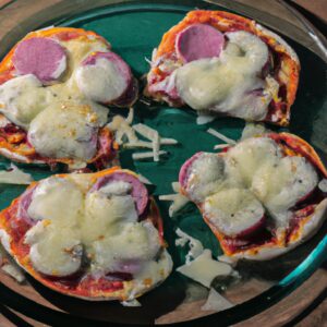 Imagem de uma pizza de rap10 feita na airfryer. A pizza tem uma crosta crocante e dourada e está coberta com molho de tomate, queijo e coberturas.