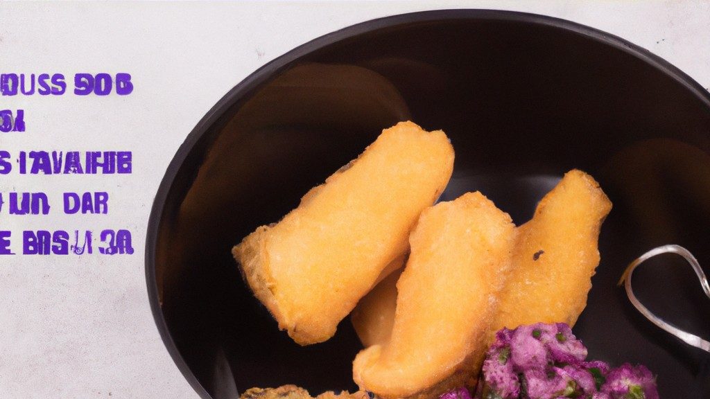 **Texto alternativo:**

Uma cesta da Airfryer contém postas de bacalhau cozidas e douradas, guarnecidas com limão e ervas frescas.