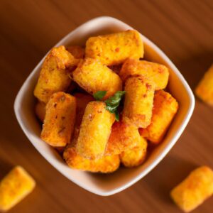 Foto de Presunto Parma colocado em uma cesta de airfryer. O presunto está dourado e crocante, com bordas levemente queimadas.