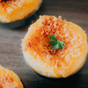 Imagem de um pudim fit assado em uma airfryer. O pudim é feito com ingredientes saudáveis, como aveia, banana e cacau em pó, e é coberto com uma calda de chocolate saudável.