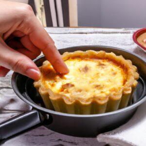 Imagem de uma quiche fit assada em uma airfryer. A quiche é feita com uma crosta de grão integral e recheada com ovos, vegetais e queijo. A quiche é coberta com uma crosta dourada e escamosa.