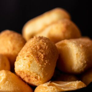 Imagem de uma bandeja de Airfryer contendo Rap10 crocantes e dourados. A bandeja está em uma superfície escura, com vapor saindo das Rap10.