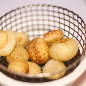 Imagem de um prato com coquinhos açucarados dourados e crocantes, preparados na Airfryer. O prato é acompanhado por um copo de leite para mergulhar os coquinhos.
