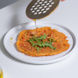 Imagem de panquecas verdes feitas com rúcula, espalhadas com tomates secos e polvilhadas com queijo parmesão.