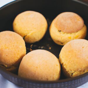 Imagem de uma torta de pão de forma assada na Airfryer. A torta é dourada e tem uma crosta crocante. O recheio é feito de maçãs picadas, canela e açúcar.