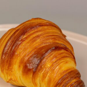 Imagem de croissants dourados e fofos preparados na airfryer, prontos para serem servidos com manteiga ou geleia. Esses croissants caseiros são fáceis de fazer e ficam prontos em apenas 30 minutos, proporcionando um café da manhã ou lanche delicioso e conveniente.