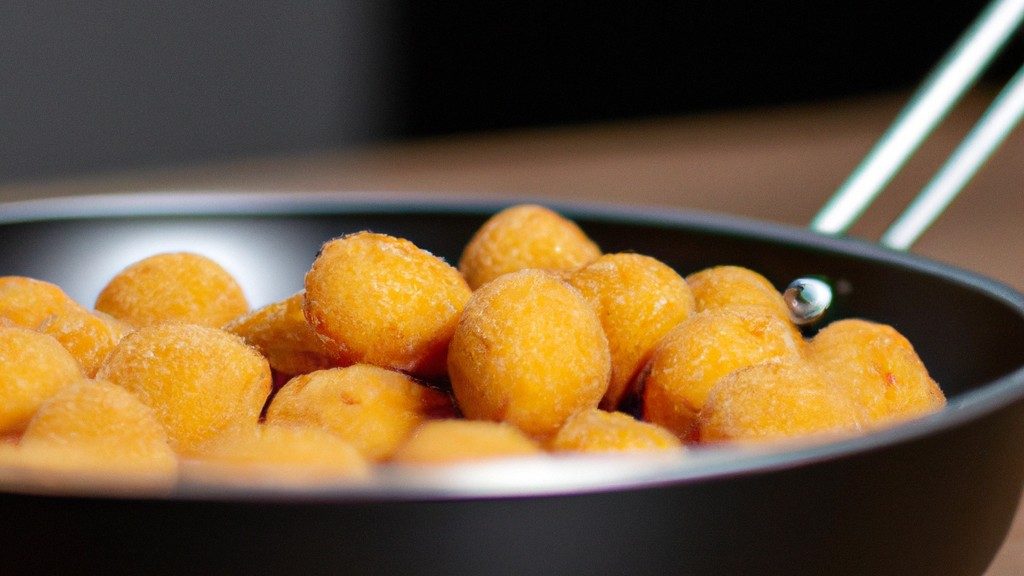 Imagem de cogumelos shimeji dourados e crocantes preparados em uma Airfryer, servidos em um prato com um raminho de alecrim fresco e um toque de limão.