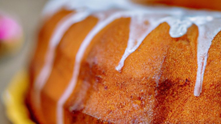 Imagem de um delicioso bolo Romeu e Julieta feito na Airfryer. O bolo tem duas camadas de pão de ló, uma camada de goiabada cremosa e uma camada de cobertura de chocolate. O bolo é coberto com chocolate ralado e cerejas frescas.