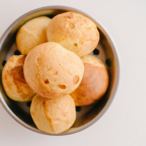 Imagem de um pão de queijo vegano dourado e crocante, cozido em uma airfryer.