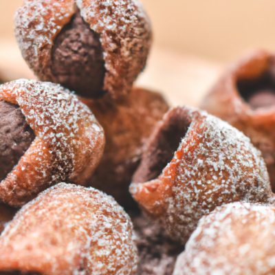 Imagem de um livro de receitas com o título "Receitas Na Airfryer Doce". O livro é azul claro e tem uma imagem de uma airfryer com doces assados dentro.