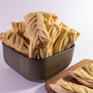 Imagem de serpentinas de massa folhada sem glúten feitas na Airfryer. As serpentinas são douradas e crocantes e estão em um prato branco.
