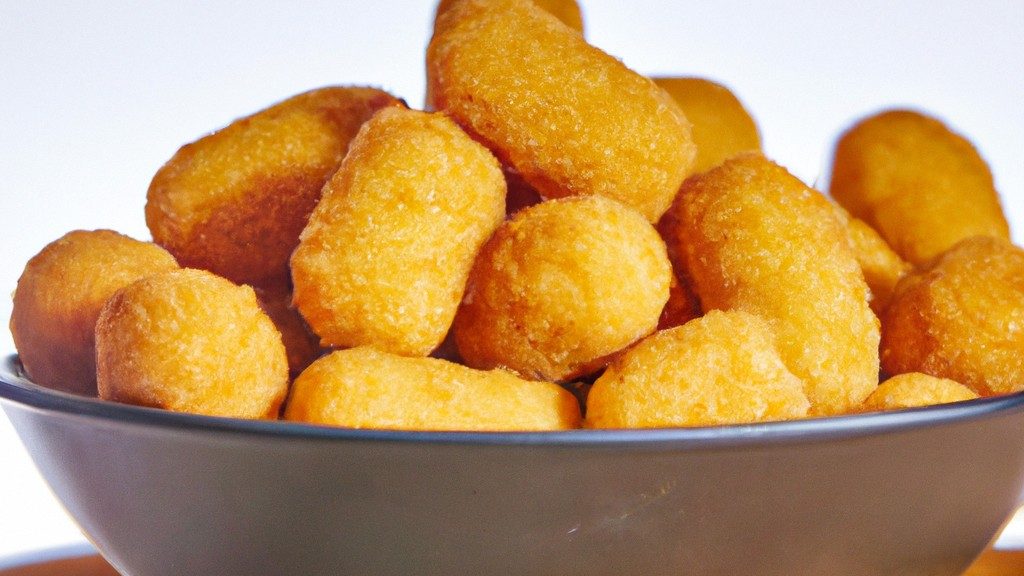 Uma imagem de uma Airfryer com várias comidas diferentes dentro, incluindo frango, batata frita e legumes. O texto na imagem diz 
