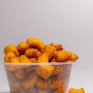 Imagem de um prato com mandioquinhas cortadas em palitos douradas e crocantes. A mandioquinha está disposta em formato de pirâmide e é acompanhada por um molho de tomate.