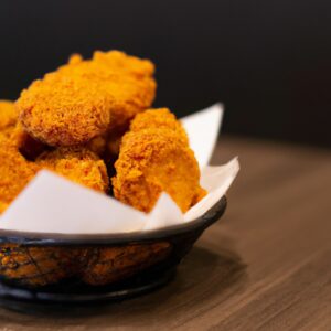 Imagem de uma sobrecoxa de frango crocante e dourada cozida em uma Airfryer. A sobrecoxa é temperada com sal, pimenta e páprica.