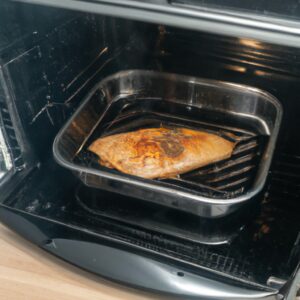 Imagem de um bife de frango dourado e suculento cozido na Airfryer, servido em um prato com legumes refogados ao lado. O bife é temperado com ervas e especiarias, dando-lhe um sabor saboroso. A Airfryer proporciona uma textura crocante por fora e macia por dentro, tornando este prato rápido e fácil de preparar.
