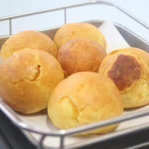Imagem de um suflê de chuchu assado na Airfryer, com uma crosta dourada e fofa. A imagem mostra o suflê cortado ao meio, revelando seu interior cremoso e fofo.