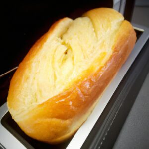 Imagem de uma torrada de pão francês dourada e crocante cozida em uma Airfryer. A torrada é polvilhada com açúcar de confeiteiro e servida com frutas frescas e xarope de bordo.