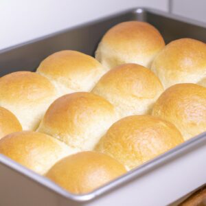 Imagem de uma cesta de Airfryer cheia de torradas de pão sírio crocantes e douradas, dispostas em camadas com queijo derretido, tomate fatiado e ervas frescas.