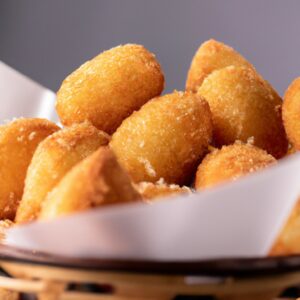 Uma foto de uma Air Fryer Airgratto com várias receitas em destaque, incluindo batatas fritas, nuggets de frango e anéis de cebola. O texto na imagem diz "Air Fryer Airgratto: Cozinhe suas comidas favoritas com rapidez e facilidade!"