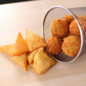 Imagem de um livro de receitas com capa vermelha e branca, com o título "Air Fryer Eos Receitas" impresso na frente. O livro está apoiado sobre uma superfície branca, com uma frigideira a ar preta ao lado.