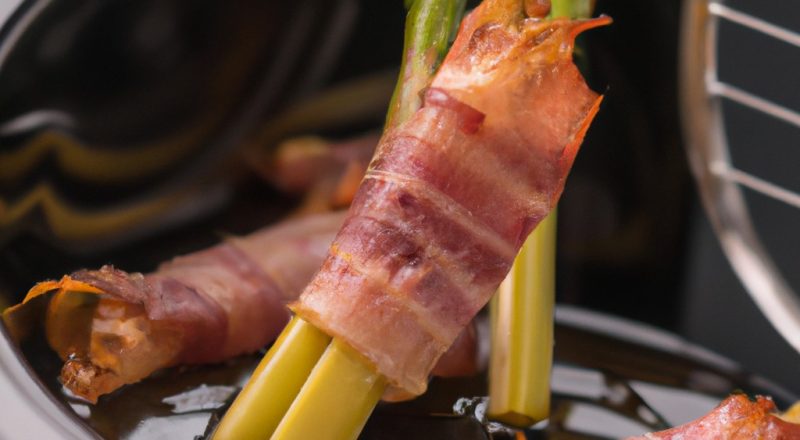 Uma imagem de aspargos verdes brilhantes e bacon crocante cozidos em uma airfryer. Os aspargos são longos e finos, com pontas tenras. O bacon está cortado em fatias finas e enrolado em torno dos aspargos. A imagem é nítida e vibrante, e o fundo é branco.