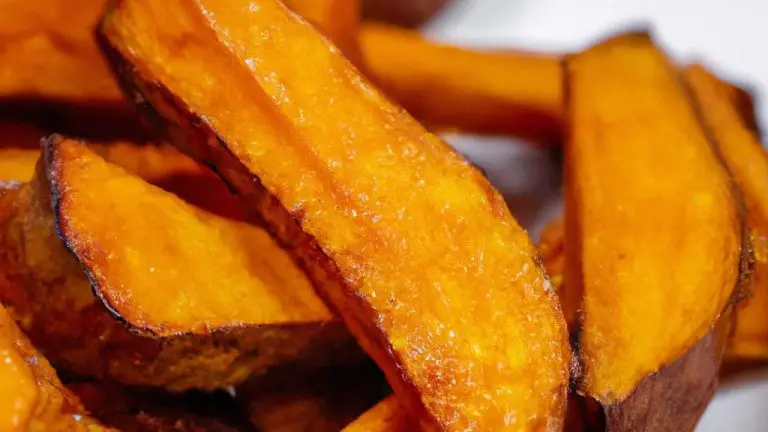 Imagem de batatas-doces caramelizadas crocantes e douradas cozidas na Airfryer. As batatas são cortadas em palitos ou fatias finas e cobertas com uma mistura doce e caramelizada. O exterior é crocante e o interior é macio e delicioso.