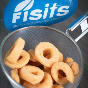 Imagem de biscoitinhos dourados e crocantes feitos com leite condensado, cozidos em uma airfryer. Eles são dispostos em uma cesta de ar quente com uma camada crocante no topo e um interior macio e derretido.