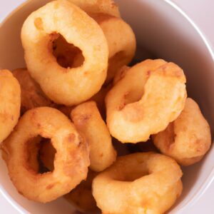 Imagem de uma variedade de biscoitinhos doces fritos em uma airfryer. Eles incluem sequilhos, brevidades, goiabinhas e rosquinhas, todos feitos com leite condensado como ingrediente principal.
