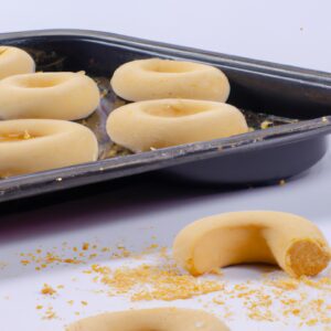Imagem de biscoitos dourados e crocantes dispostos em uma cesta de fritadeira de ar. Os biscoitos são fofos e folhosos, com bordas levemente douradas. A fritadeira de ar é visível ao fundo, com uma cesta de aramado e um elemento de aquecimento exposto.