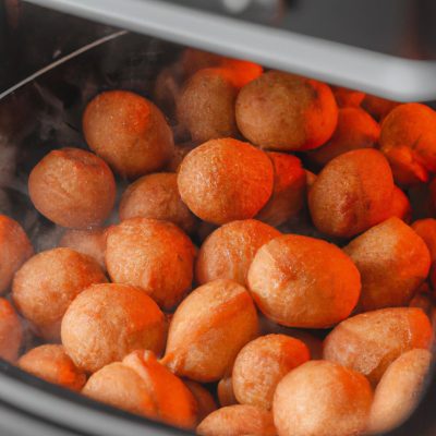 Imagem de bolinhos de linguiça fritos na Airfryer. Os bolinhos são dourados e crocantes, com um recheio suculento de linguiça. Eles estão servidos em um prato com um molho de mostarda ao lado.