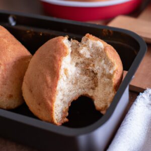 Foto de um prato cheio de bolinhos salgados crocantes e dourados feitos na airfryer. Os bolinhos têm uma crosta escamosa e um recheio saboroso, que pode ser visto através dos buracos.
