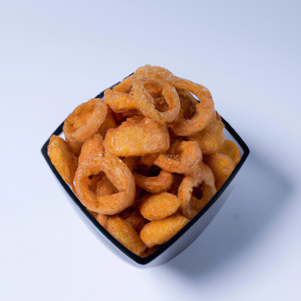 Imagem de cebolas fritas crocantes feitas em uma Airfryer. As cebolas são douradas e crocantes, e estão dispostas em uma tigela.