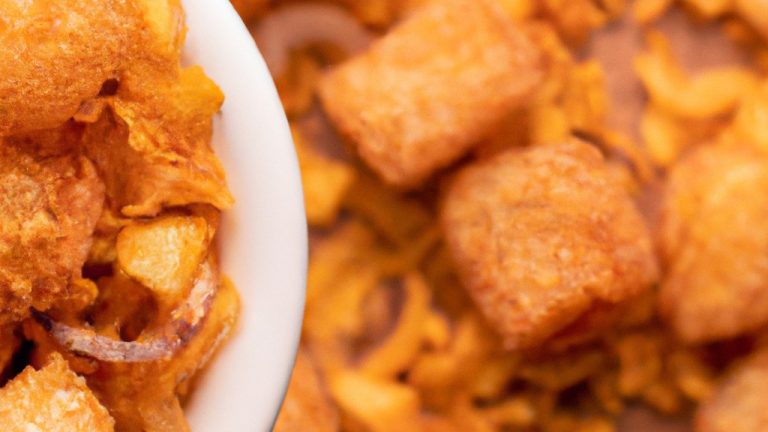 Imagem de cebolas cortadas em rodelas e empanadas em uma tigela, prontas para serem colocadas na Airfryer. A legenda diz 