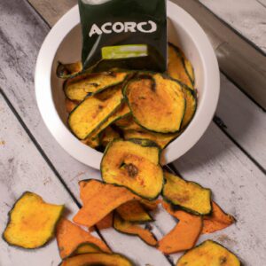Imagem de uma cesta de fritadeira cheia de chips de abobrinha fritos e crocantes, guarnecidos com ervas frescas e sal marinho.