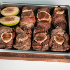 Imagem de um prato com churrasquinho grego feito na Airfryer. Os pedaços de carne estão dourados e suculentos, espetados em palitos de madeira. O prato é acompanhado por arroz, salada e molho tzatziki.