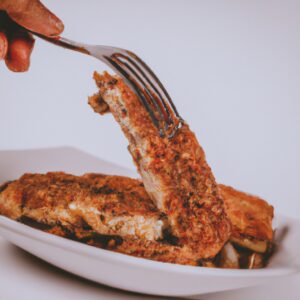 Imagem de uma banana empanada frita na air fryer, com uma crosta dourada e crocante. A banana está fatiada em rodelas e empanada em uma mistura de farinha de rosca, queijo parmesão e especiarias.