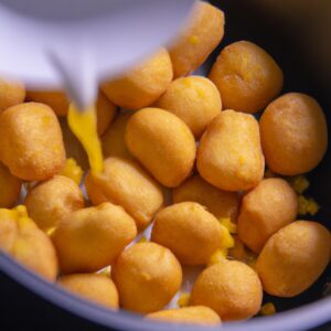 Imagem de uma polenta frita dourada em formato de palitos, servida em um prato com um molho de tomate ao lado.