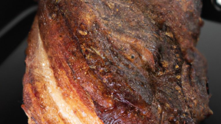 Imagem de uma costela bovina assada no bafo na Airfryer. A costela é suculenta e macia, com uma crosta crocante e dourada. É guarnecida com ervas frescas e fatias de limão.