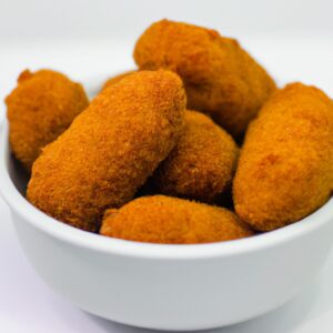 Imagem de croquetes de carne dourados e crocantes servidos em um prato, preparados na Air Fryer. Os croquetes são recheados com carne moída temperada e cobertos com farinha de rosca, criando uma crosta crocante e saborosa.