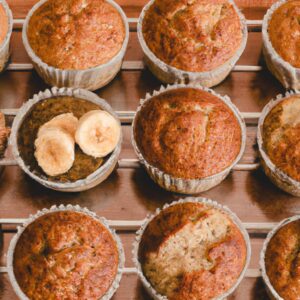 Imagem de um cupcake integral de banana e aveia assado em uma Airfryer. O cupcake é dourado e tem uma textura crocante por fora e um miolo macio e fofinho por dentro. O cupcake é coberto com uma cobertura de cream cheese e polvilhado com aveia.