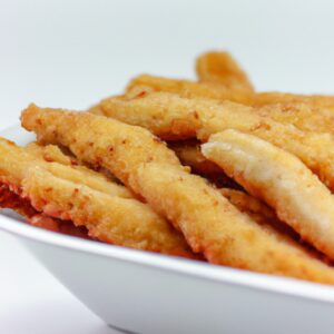 Imagem de filés de peixe empanados fritos na airfryer, crocantes e dourados, acompanhados de molho tártaro e limão.
