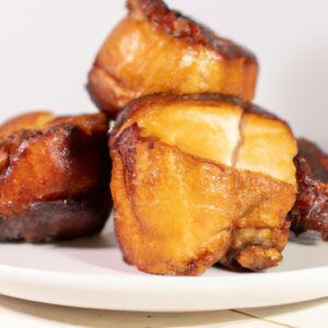 Imagem de um galeto desossado assado na airfryer, com a pele dourada e crocante. O galeto está disposto em uma travessa branca, com uma guarnição de batatas assadas e cenouras ao lado.