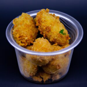 Imagem de manjubinha frita na Airfryer, apresentando pedaços dourados e crocantes da iguaria brasileira. A manjubinha é uma pequena fruta nativa do Brasil, comumente consumida frita ou assada. A Airfryer permite uma fritura mais saudável, resultando em uma manjubinha crocante e saborosa sem o excesso de óleo.