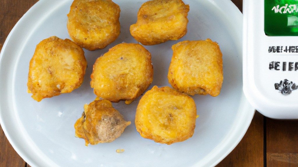 Nuggets Congelados Na Airfryer: Como Fazer No Tempo Certo 1 Imagem de nuggets de frango congelados dourados e crocantes servidos em uma tigela branca com um lado de molho de tomate. Os nuggets são empanados e têm um interior branco e macio. A tigela está sobre uma superfície de madeira com um pano de prato xadrez vermelho e branco ao lado.